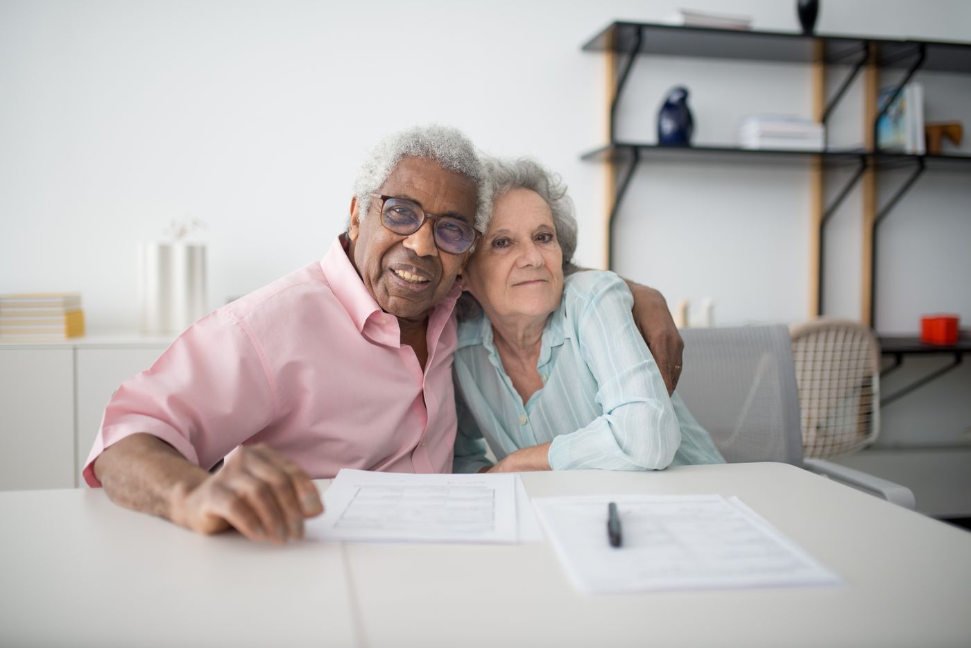 An older couple smiling while reviewing their policy documents together
